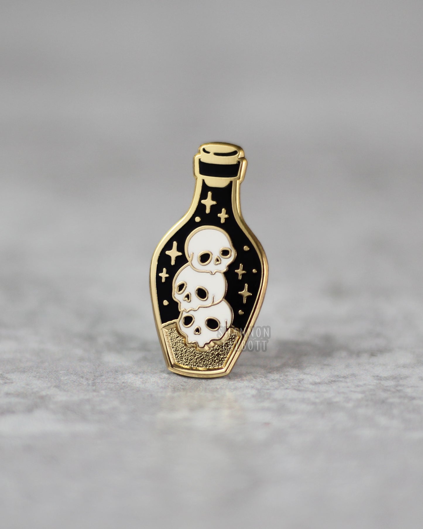 Dark Potion Enamel Pin with Skulls in Gold Plating