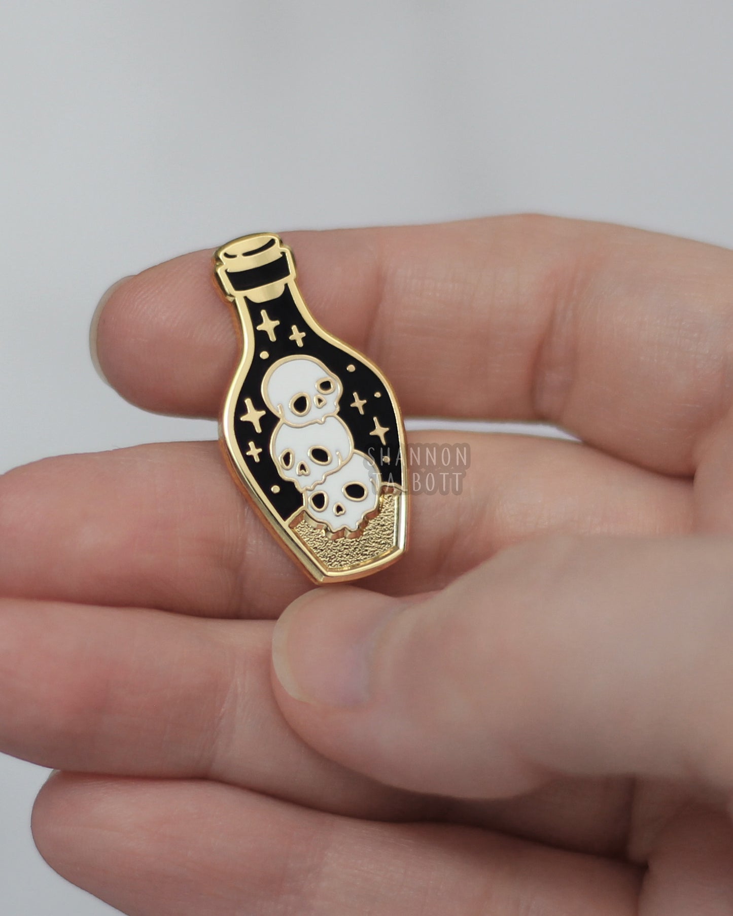 Dark Potion Enamel Pin with Skulls in Gold Plating